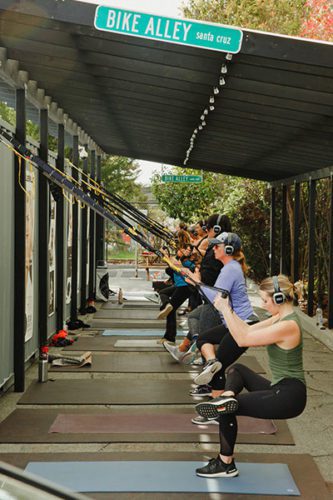 Fitness class students wearing Sound Off headphones at GOAT Santa Cruz