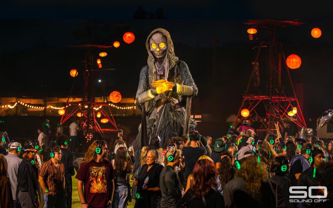 Audience wearing green-glowing silent disco headphones at The Cortège